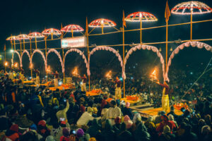 Varanasi, Uttar Pradesh, India - December 26, 2019: A crowd of people gathers on the bank of river Ganga to take part in the Aarti ritual. Hindu Pandits of Varanasi perform the Ganga Aarti ritual every evening for one hour from 6 pm onward at Dashashwamedh Ghat.